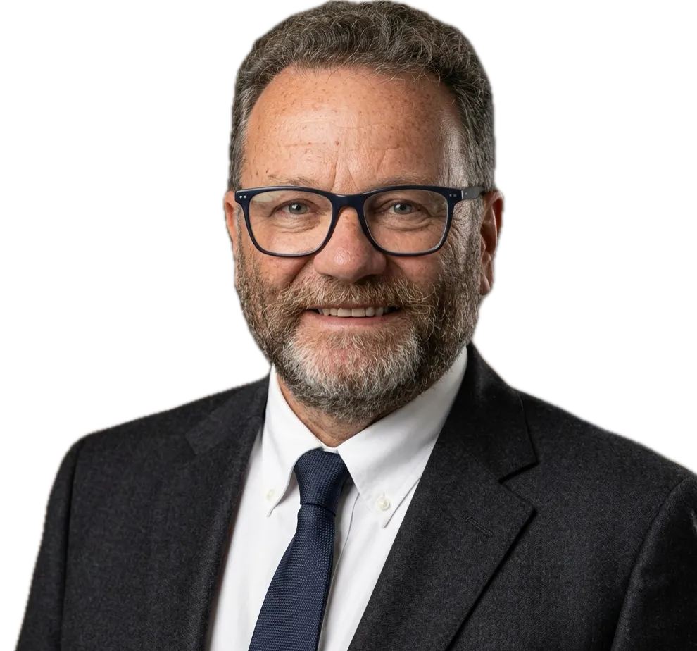 Professional headshot of Amira Hamit, wearing a suit and tie, smiling.
